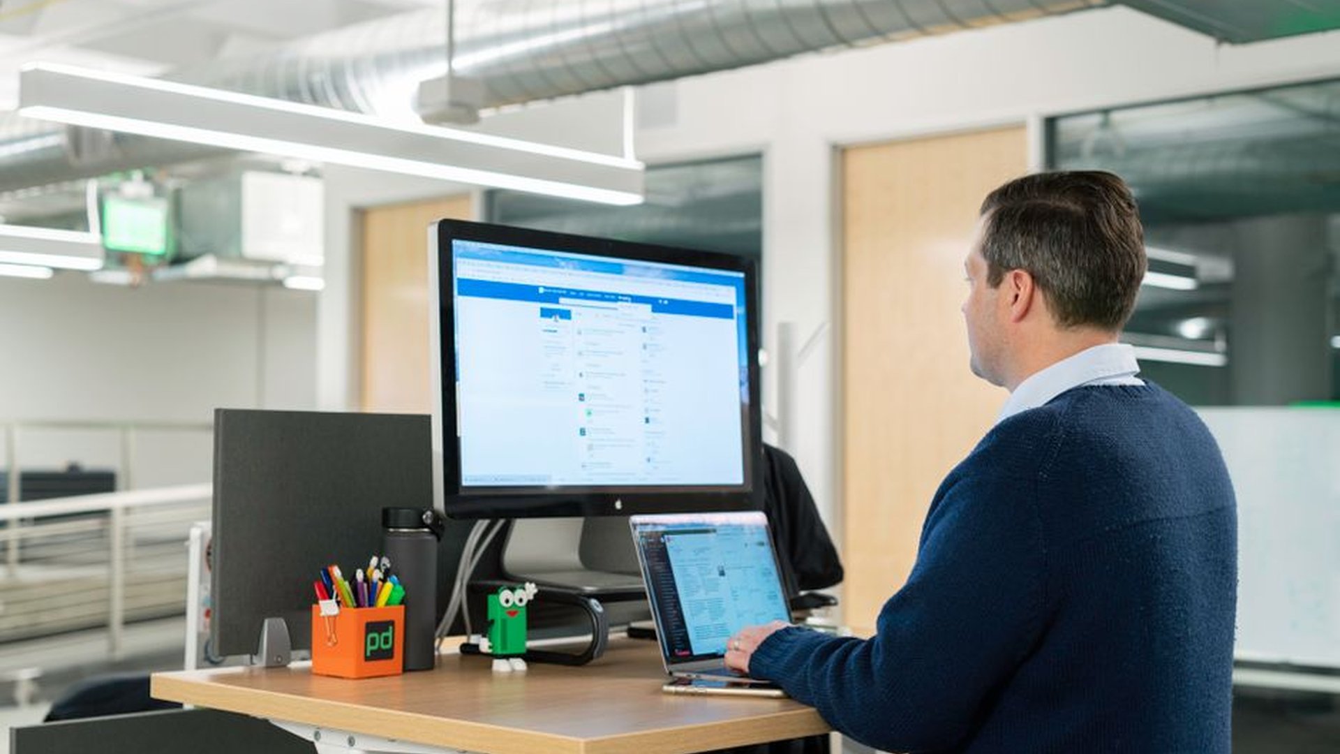 standing desk office worker focused computer scree