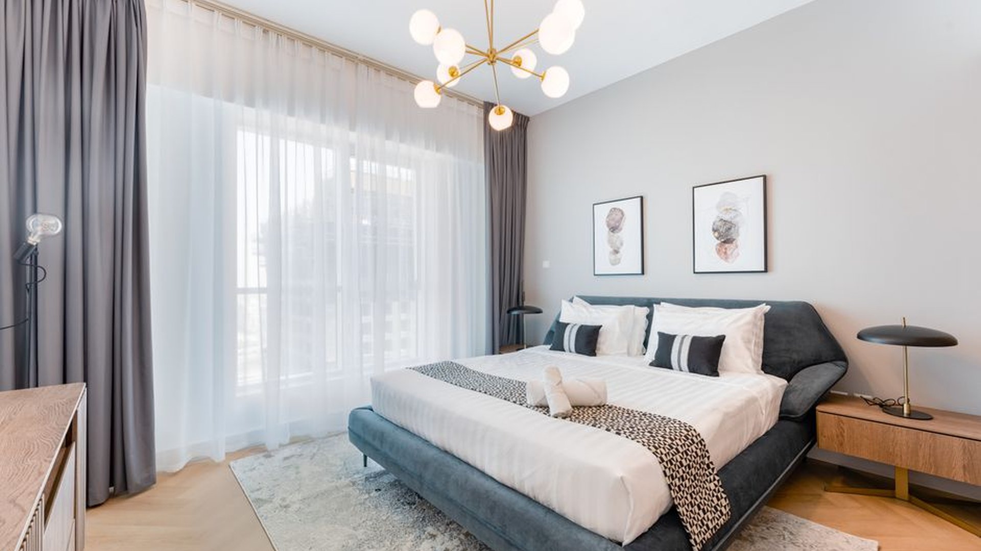 king bed white walls light wood floors bright room